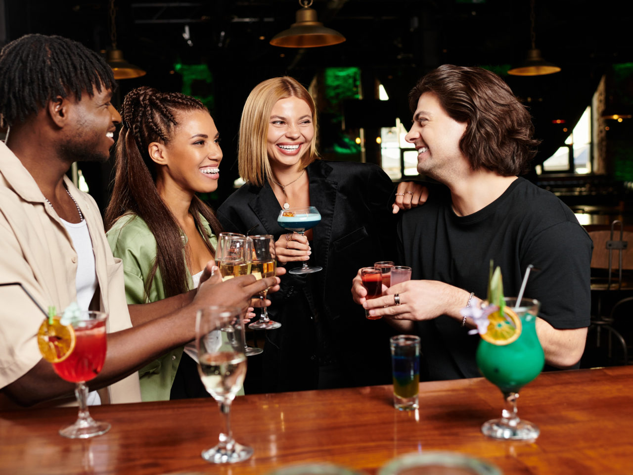 A group of young professionals celebrates together, sharing drinks and smiles at a corporate event.